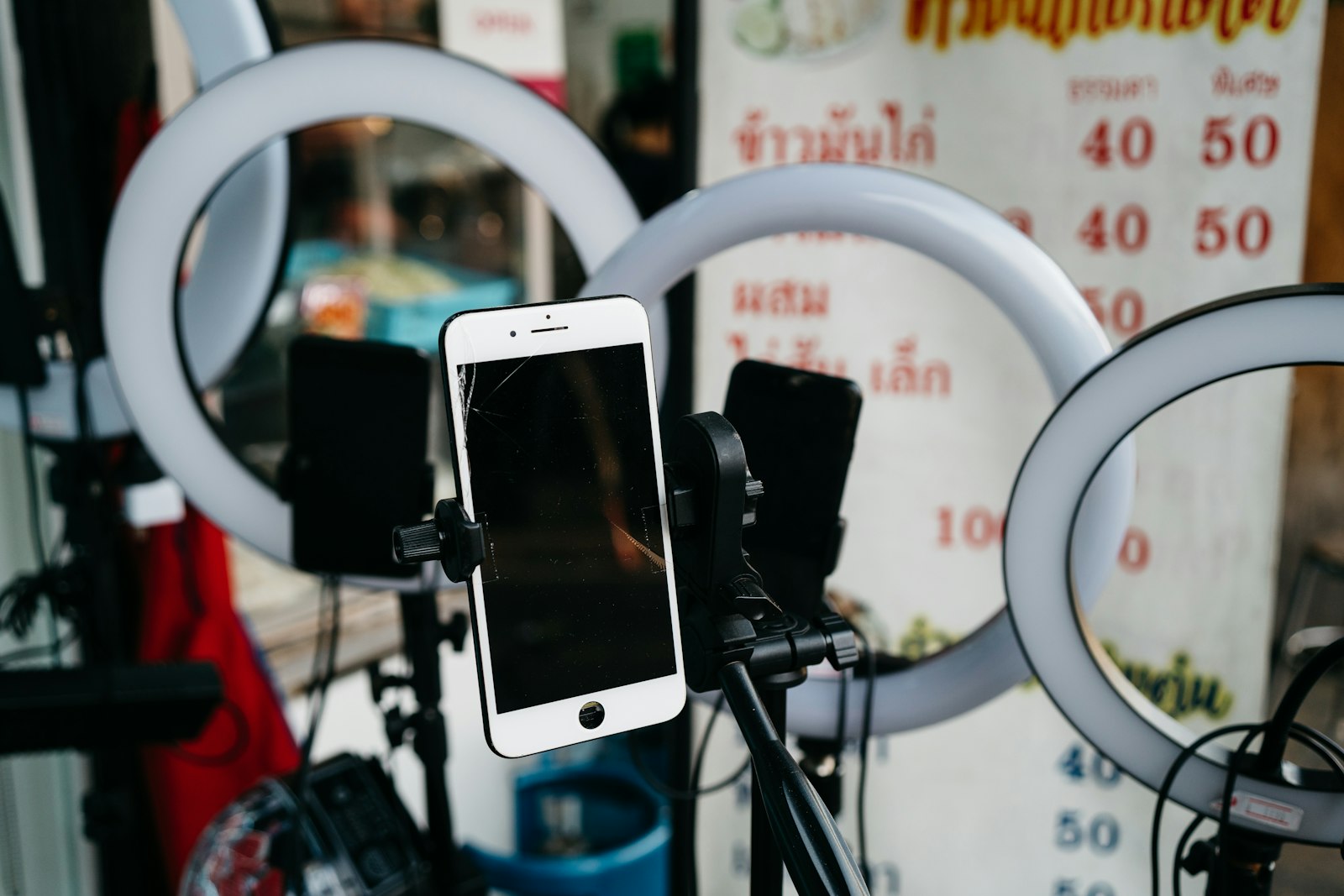 Phone on a tripod with ring lights set up on a Thai street
